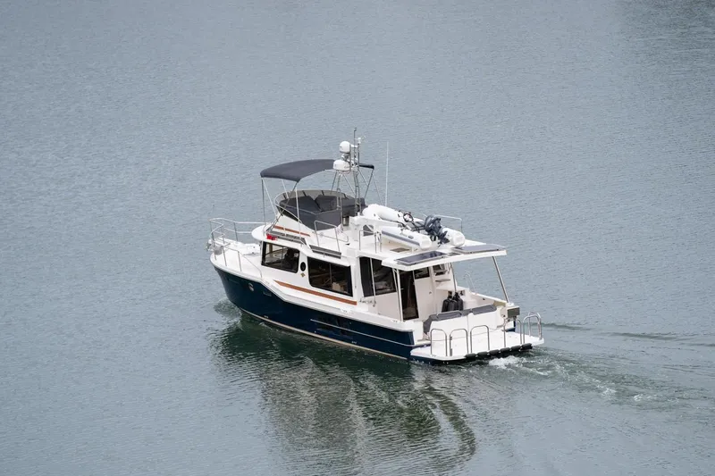 Slide: The Image of 2025 Ranger Tugs R-43 Command Bridge Luxury Edition cruising on calm water. - 1