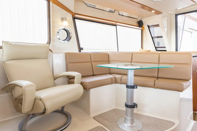 Slide: The Image of Luxurious interior of 2025 Ranger Tugs R-43 Command Bridge with leather seating and glass table. - 13