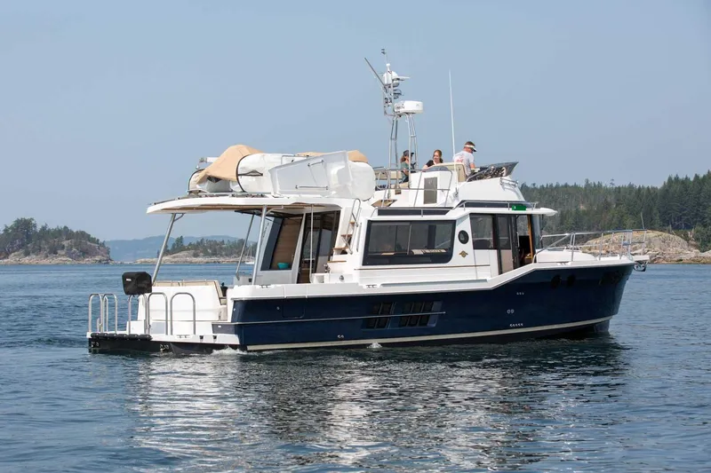 Slide: The Image of 2025 Ranger Tugs R-43 Command Bridge Luxury Edition cruising on a serene lake. - 5