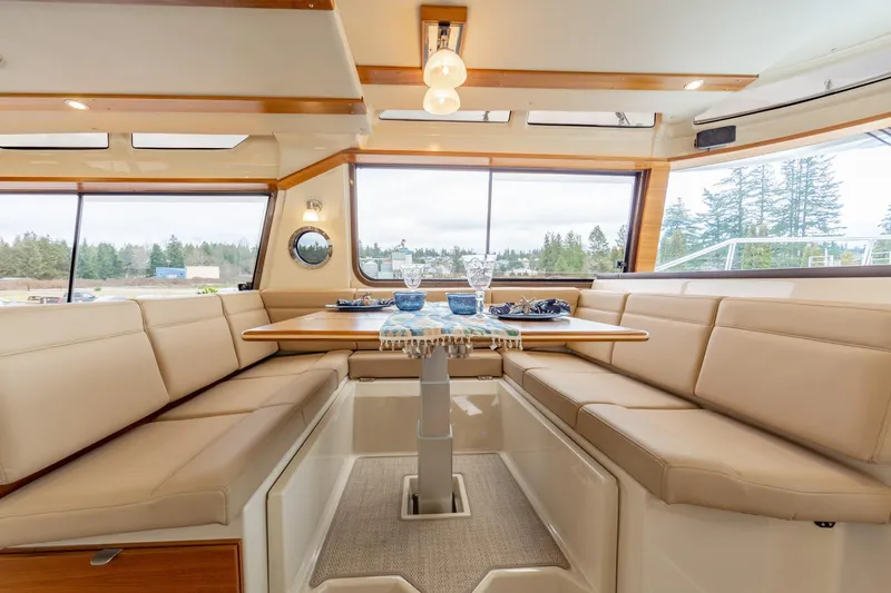 Slide: The Image of Interior of 2025 Ranger Tugs R-43 Sedan with elegant dining area and panoramic windows. - 4