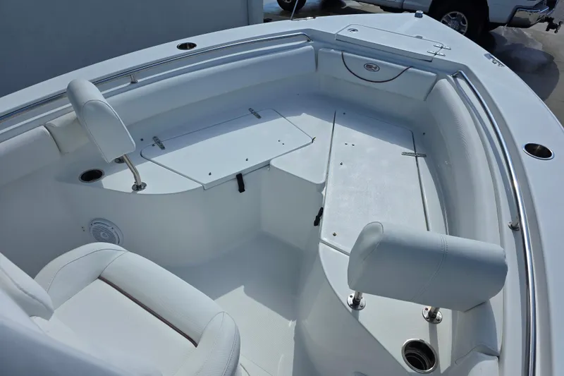Slide: The Image of 2019 Sea Hunt Ultra 211 boat interior with white seating and storage compartments. - 11