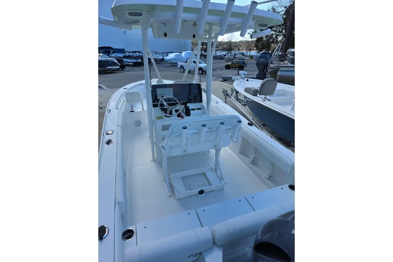 Slide: The Image of 2019 Sea Hunt Ultra 211 boat interior with helm and seating, docked at marina. - 13