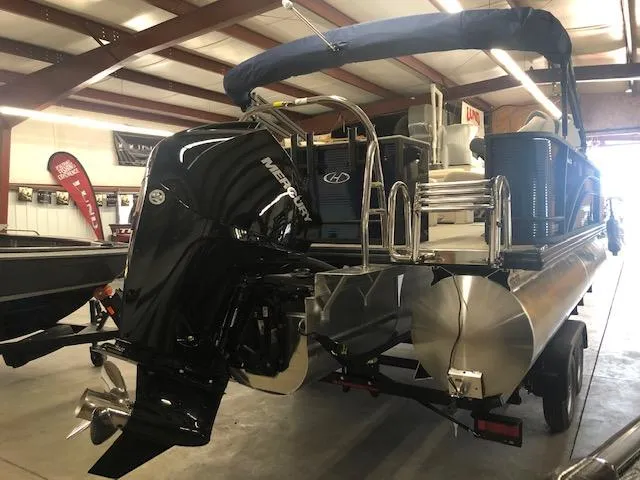 Slide: The Image of 2023 Harris Cruiser 230 pontoon boat with Mercury outboard motor in a showroom. - 3