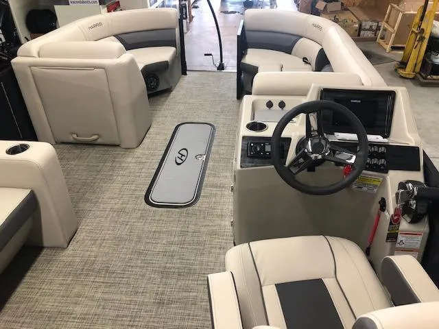 Slide: The Image of 2023 Harris Cruiser 230 boat interior with beige seating and modern dashboard. - 5