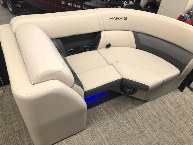 Slide: The Image of 2023 Harris Cruiser 230 boat seating with beige upholstery and blue LED lighting. - 7