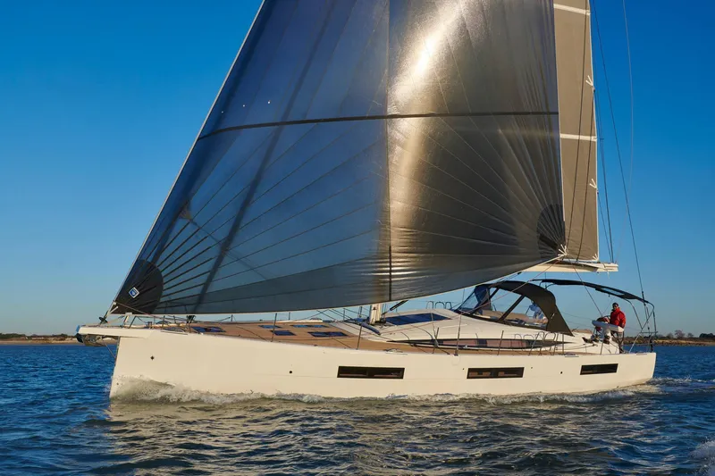 The Image of 2024 Jeanneau 60 yacht sailing on open water under clear blue skies. - 0