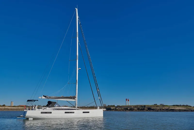 Slide: The Image of 2024 Jeanneau 60 sailboat on calm water under clear blue sky. - 2