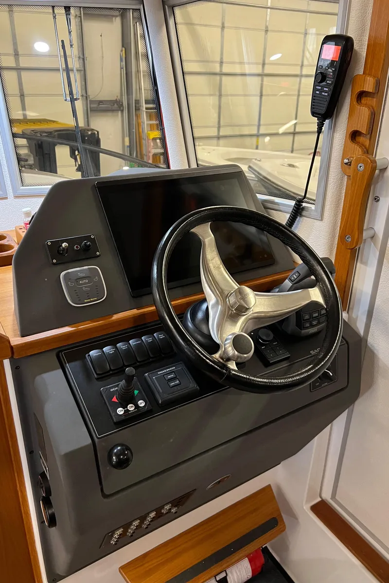 Slide: The Image of Control panel of a 2021 Sargo 25 boat with steering wheel and navigation equipment. - 1