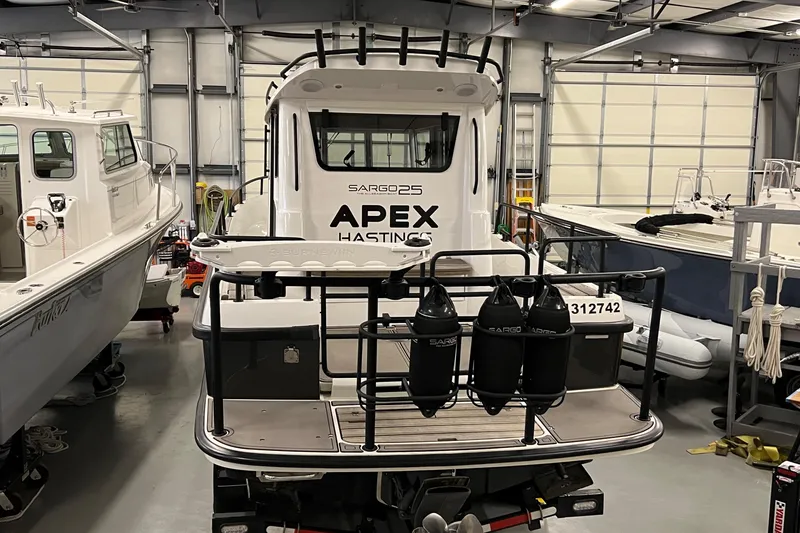 Slide: The Image of 2021 Sargo 25 boat in a storage facility, rear view with fenders and equipment. - 12