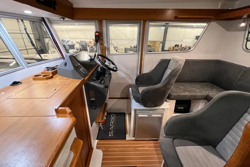 Slide: The Image of Interior of a 2021 Sargo 25 boat with modern seating and wooden finishes. - 15