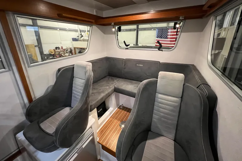Slide: The Image of Interior of a 2021 Sargo 25 boat with gray seating and wooden accents. - 2