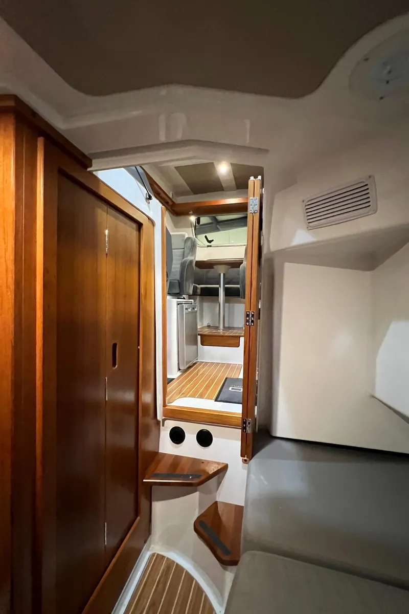 Slide: The Image of Interior of 2021 Sargo 25 boat with wooden cabinetry and seating area. - 25