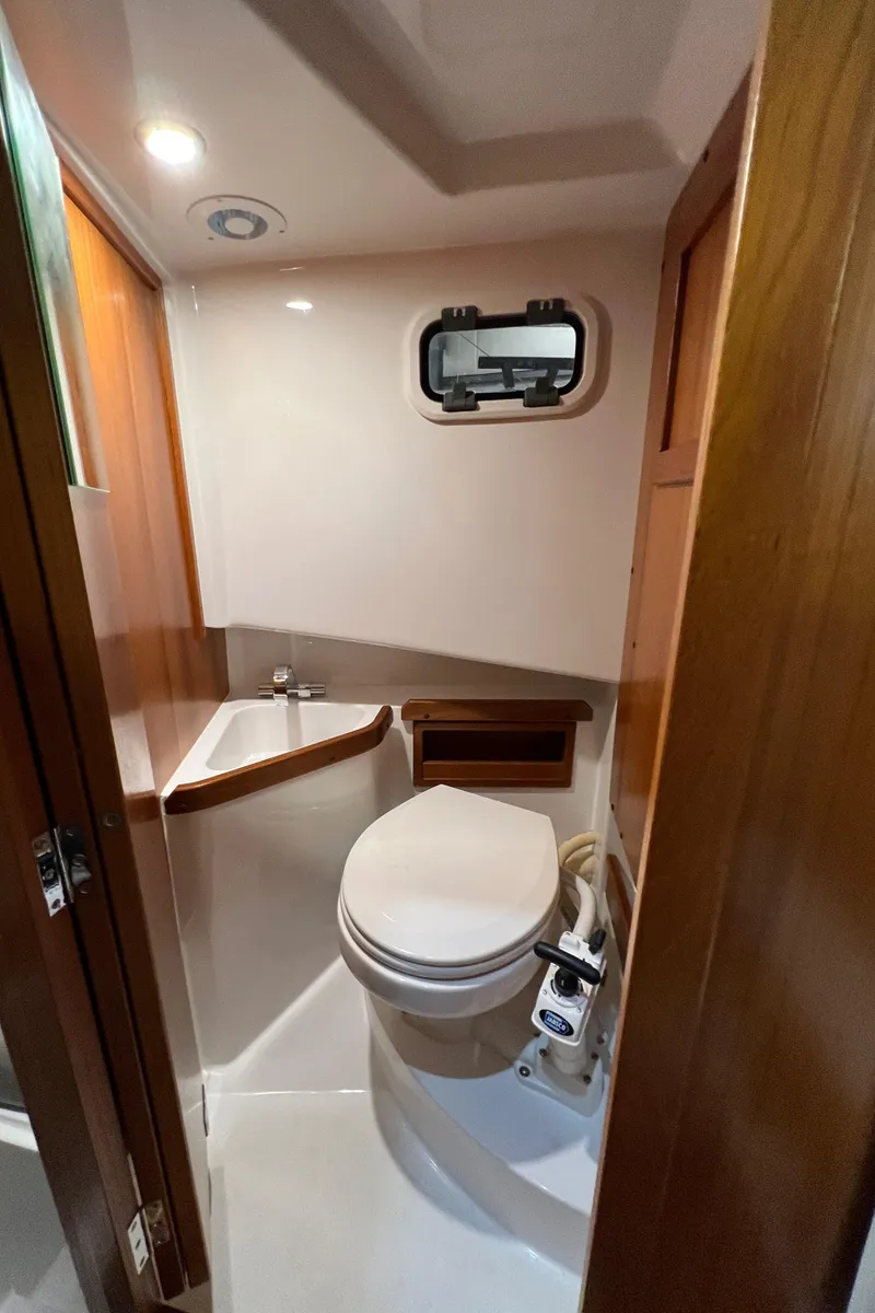 Slide: The Image of Compact bathroom in 2021 Sargo 25 boat with toilet, sink, and porthole window. - 26