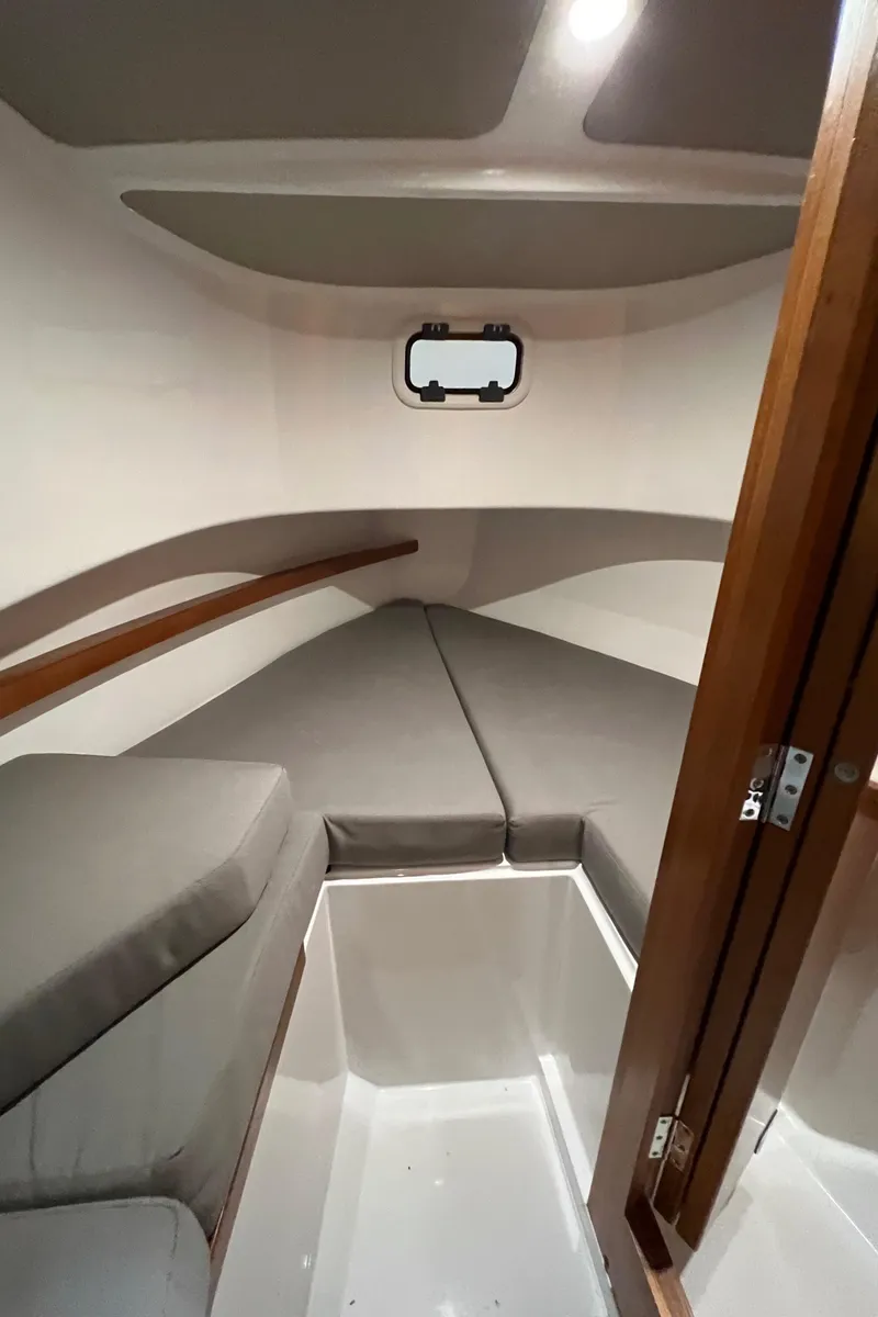 Slide: The Image of Interior cabin of a 2021 Sargo 25 boat with cushioned seating and a small window. - 28