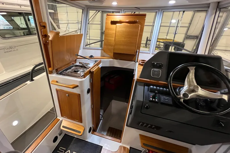 Slide: The Image of Interior of a 2021 Sargo 25 boat with steering wheel and kitchenette. - 3