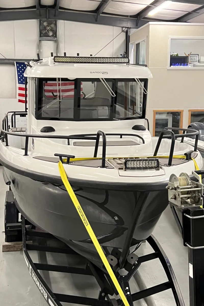 Slide: The Image of 2021 Sargo 25 boat in a showroom with an American flag in the background. - 7