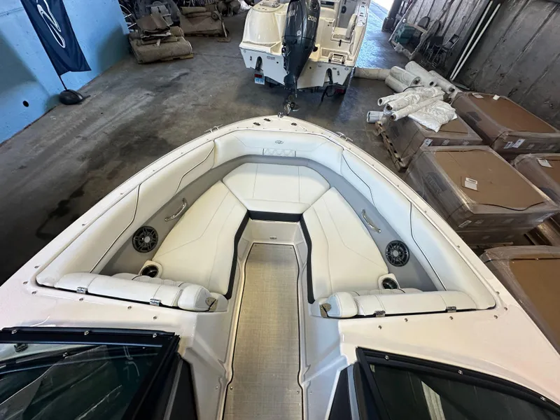 Slide: The Image of 2025 Regal LX2 boat interior with white seating and speakers in a garage setting. - 18