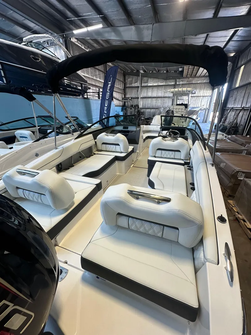 Slide: The Image of 2025 Regal LX2 boat displayed in a showroom, sleek design, white exterior. - 5