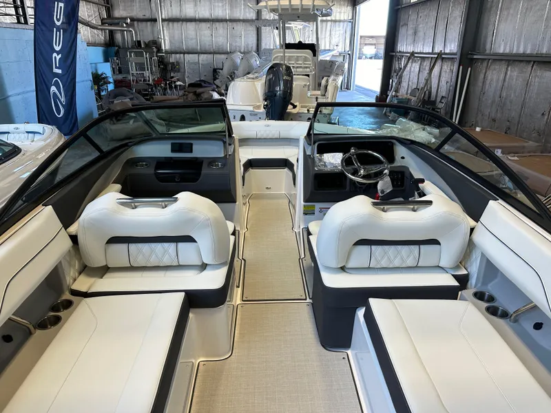 Slide: The Image of 2025 Regal LX2 boat with white seating in a showroom. - 8