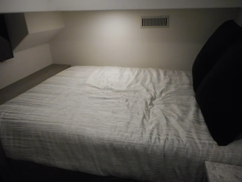 Slide: The Image of Compact bedroom in Adonia Just Add Water Trip 13, 2021 model, featuring a cozy bed with black pillows. - 10