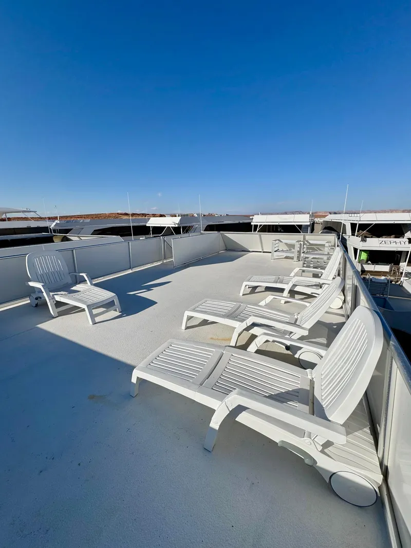 Slide: The Image of White deck chairs on Adonia's "Just Add Water Trip #13" boat, 2021, under clear blue sky. - 29