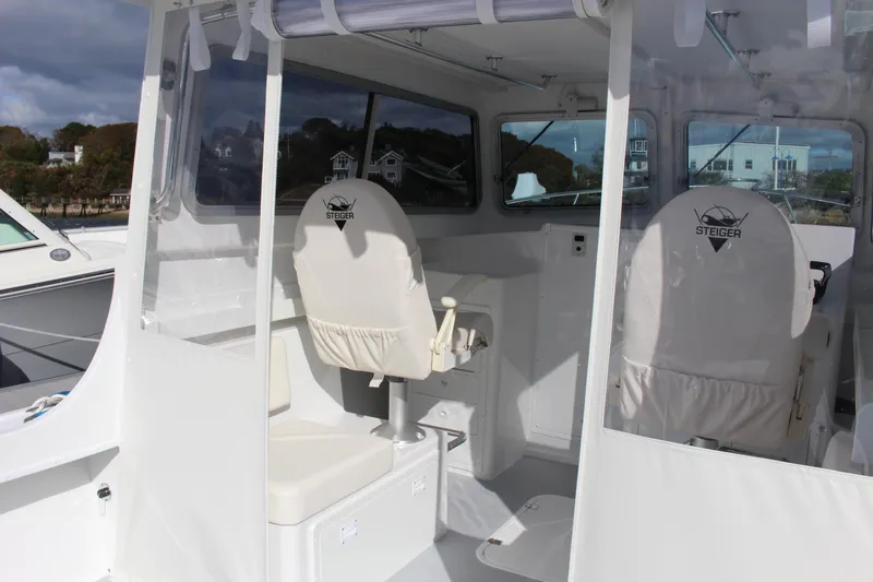 Slide: The Image of 2024 Steiger Craft 31 Miami boat interior with white seating and steering console. - 14