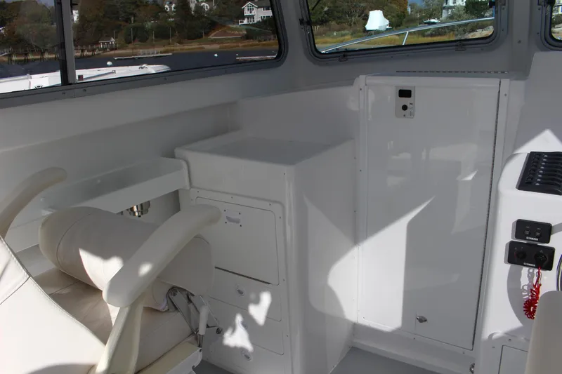Slide: The Image of 2024 Steiger Craft 31 Miami boat interior with white seating and storage compartments. - 23