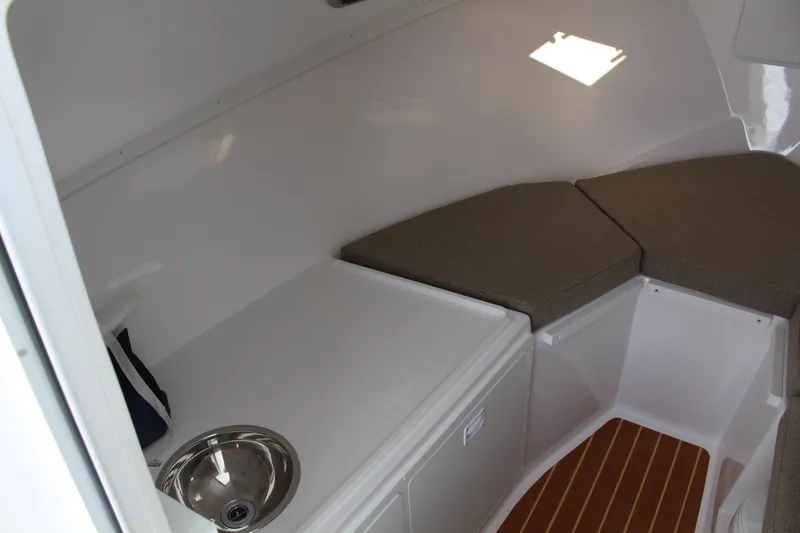 Slide: The Image of 2024 Steiger Craft 31 Miami cabin interior with sink and cushioned seating. - 29