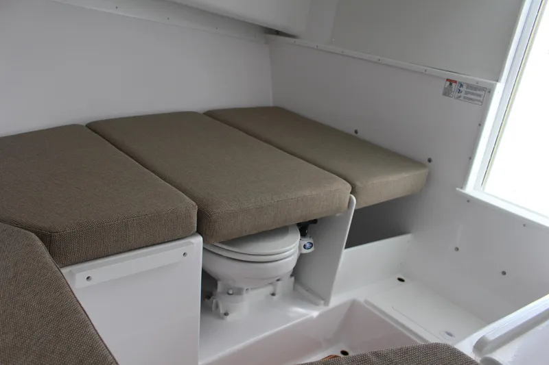 Slide: The Image of 2024 Steiger Craft 31 Miami cabin interior with cushioned seating and marine toilet. - 33