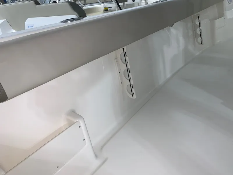 Slide: The Image of 2024 Key West 239 FS boat interior, featuring rod holders and cushioned side panels. - 10