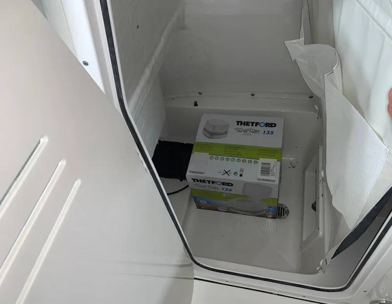 Slide: The Image of Storage compartment of 2024 Key West 239 FS boat with Thetford Porta Potti 135. - 5