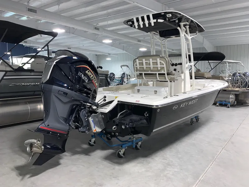 Slide: The Image of 2024 Key West 230 Bay Reef boat in showroom with outboard motor. - 1