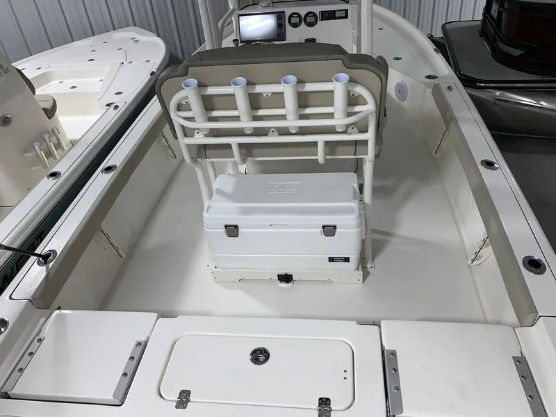 Slide: The Image of 2024 Key West 230 Bay Reef boat interior with rod holders and cooler. - 3