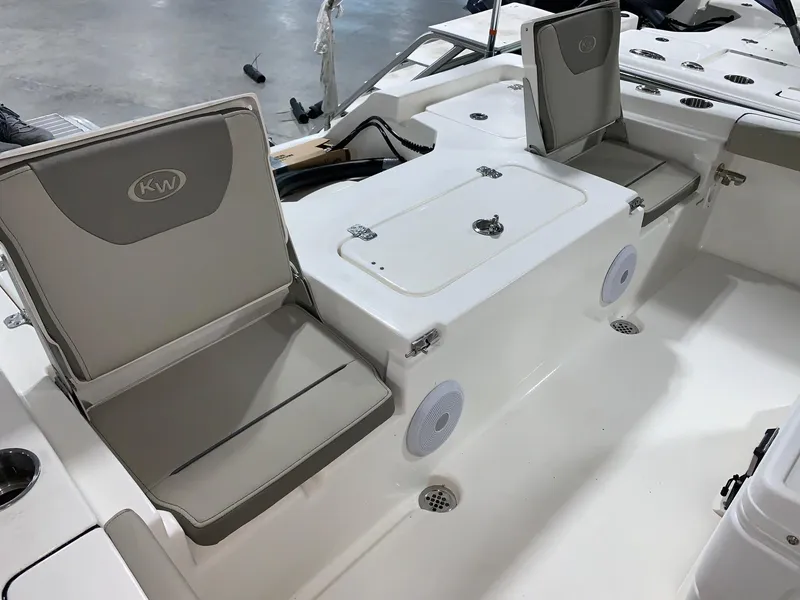 Slide: The Image of 2024 Key West 230 Bay Reef boat interior with cushioned seating and storage compartments. - 4