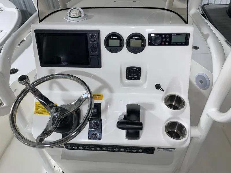 Slide: The Image of 2024 Key West 230 Bay Reef boat console with steering wheel, gauges, and controls. - 6