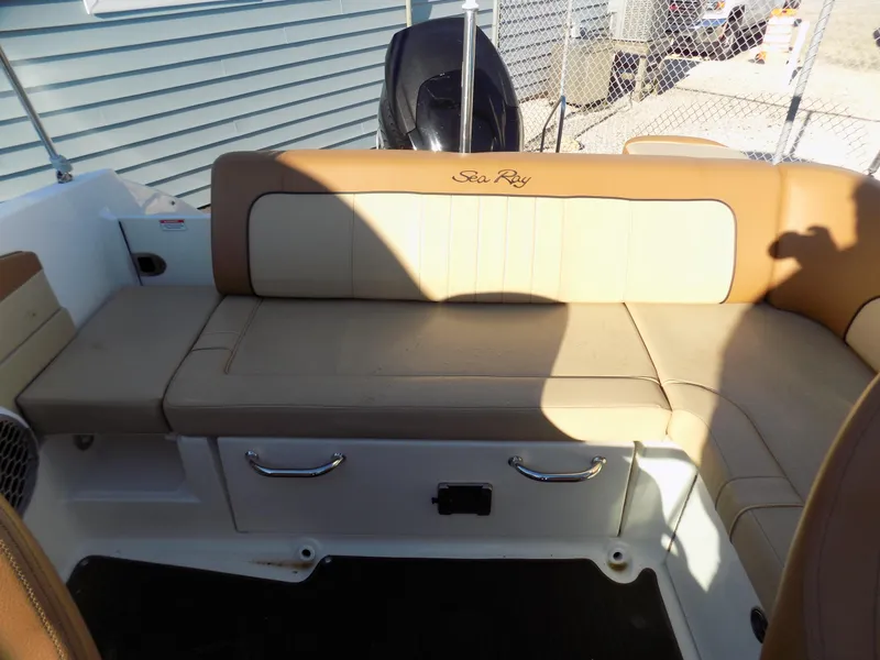 Slide: The Image of 2014 Sea Ray 220 Sundeck boat interior with tan seating and storage compartments. - 10