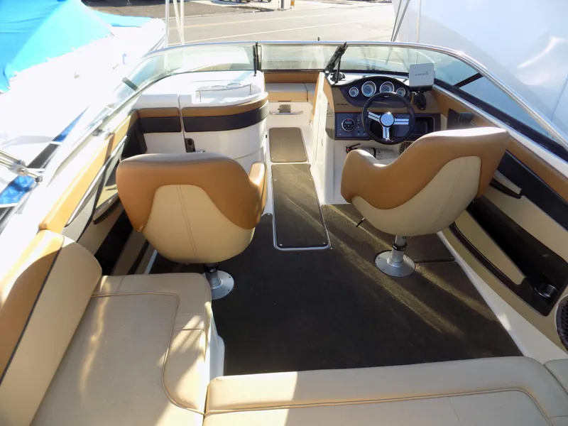 Slide: The Image of 2014 Sea Ray 220 Sundeck interior with tan seating and modern dashboard. - 3