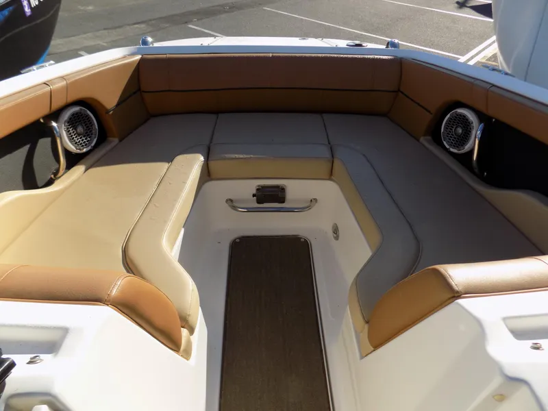 Slide: The Image of 2014 Sea Ray 220 Sundeck interior with tan seating and built-in speakers. - 4