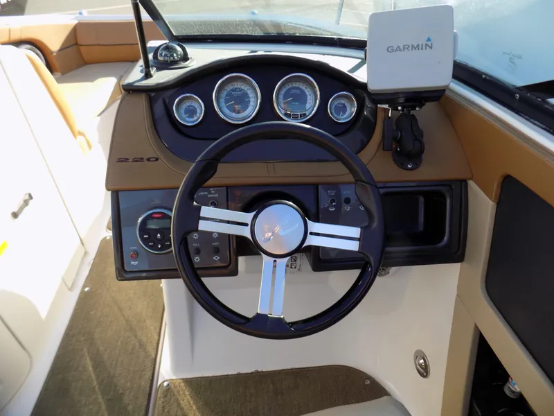 Slide: The Image of 2014 Sea Ray 220 Sundeck dashboard with steering wheel and Garmin navigation system. - 5