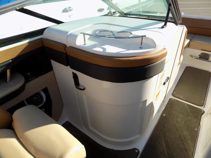 Slide: The Image of 2014 Sea Ray 220 Sundeck interior with beige seating and sleek dashboard design. - 6