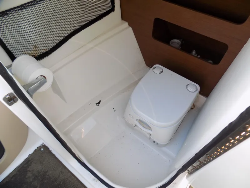 Slide: The Image of 2014 Sea Ray 220 Sundeck boat toilet area with portable toilet and storage. - 7