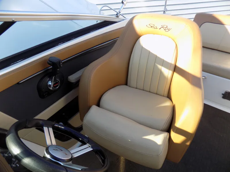 Slide: The Image of 2014 Sea Ray 220 Sundeck boat interior with tan leather seating and steering wheel. - 8