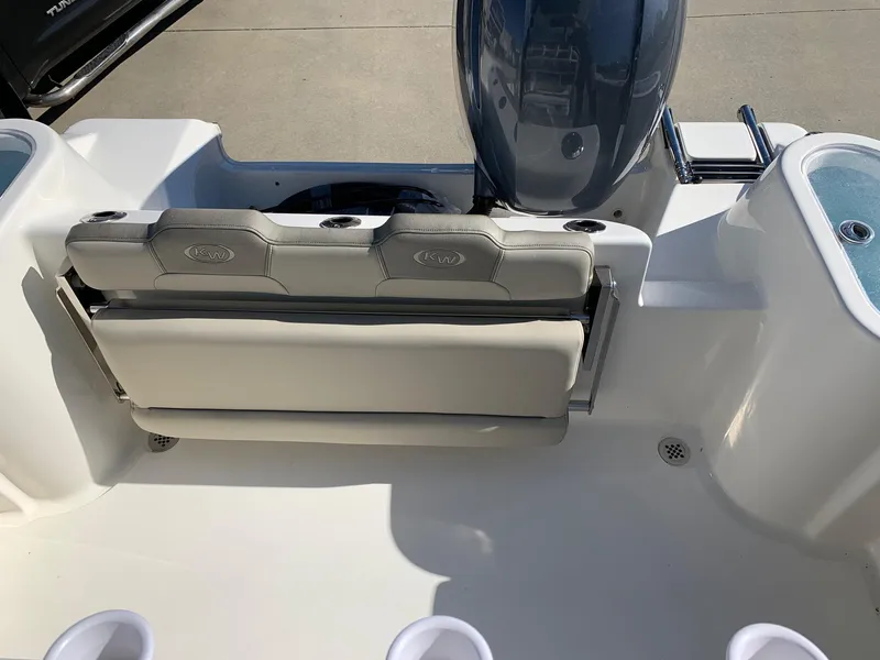 Slide: The Image of 2024 Key West 244 CC boat interior with cushioned seating and motor. - 10