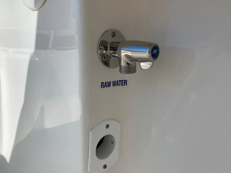 Slide: The Image of 2024 Key West 244 CC raw water outlet on white boat exterior. - 32