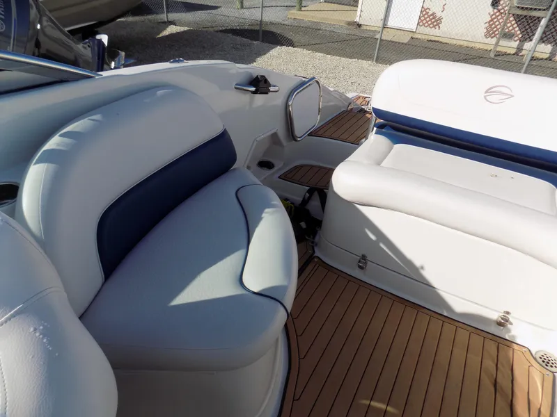 Slide: The Image of 2013 Crownline Eclipse E4 boat interior with white seating and wooden deck. - 11