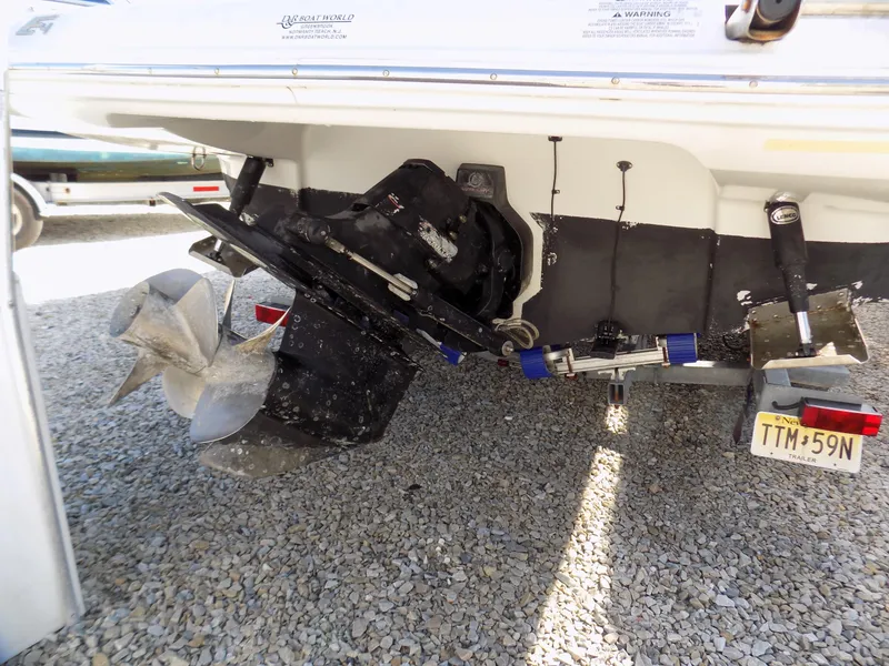 Slide: The Image of 2013 Crownline Eclipse E4 boat stern with dual propellers on gravel surface. - 15