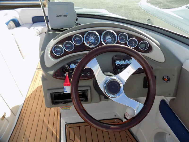 Slide: The Image of 2013 Crownline Eclipse E4 boat dashboard with Garmin GPS and wooden steering wheel. - 7