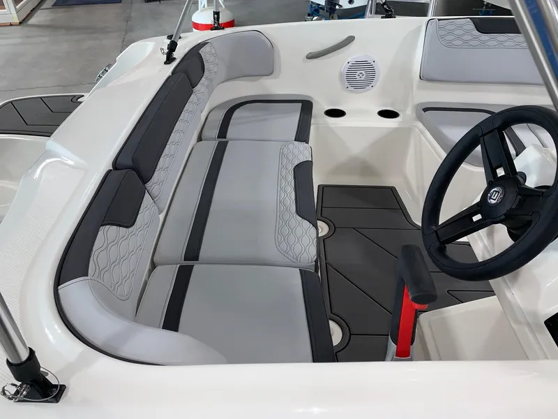 Slide: The Image of 2024 Bayliner Element M15 boat interior with gray and black seating and steering wheel. - 4