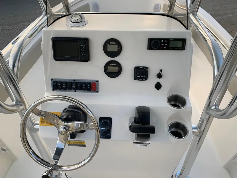 Slide: The Image of 2024 Key West 203 FS boat console with steering wheel, gauges, and controls. - 7