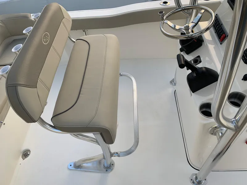 Slide: The Image of 2024 Key West 203 FS boat interior with steering console and cushioned seating. - 10